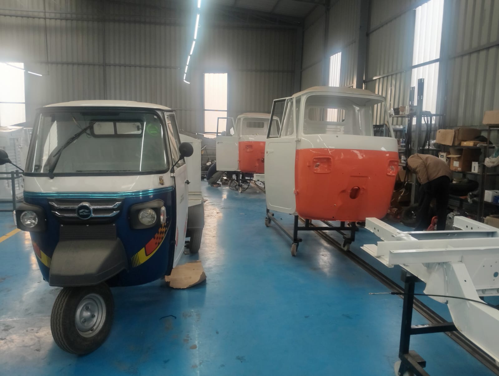 Victory branded electric three-wheeler and cabin shells on an EV assembly line