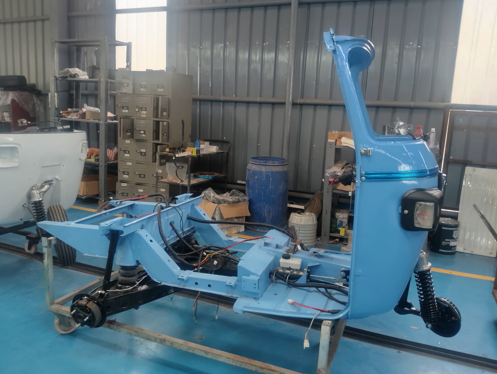 Electric three-wheeler chassis and wiring harness during assembly at an EV manufacturing partner unit